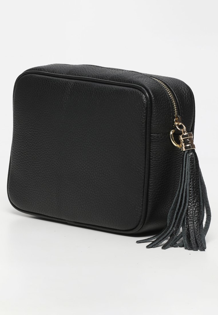 Borsa in pelle nera texturizzata con zip dorata e nappina in pelle nera su sfondo bianco.