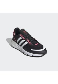 Zapatilla deportiva negra con parte superior de malla, acentos rosas y tres rayas blancas. Presenta una suela acolchada y una suela exterior de goma texturizada.
