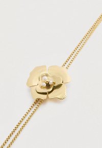 Χρυσό κρεμαστό κόσμημα σε σχήμα λουλουδιού με επάλληλα πέταλα και ραβδωτή υφή, διαθέτοντας τρία μικρά λευκά μαργαριτάρια στο κέντρο και διπλή αλυσίδα.