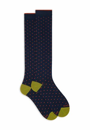 Navy blue knee-high socks with small orange polka dots and olive green toe, heel, and top trim.