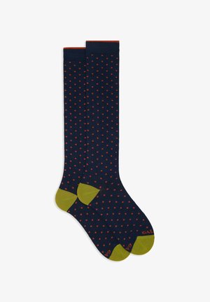 Calze blu navy al ginocchio con piccoli pois arancioni e rifiniture verde oliva su punta, tallone e parte superiore.