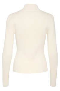 Maglione a collo alto colore crema, a coste, con maniche lunghe e design aderente, che mette in mostra una consistenza liscia e una costruzione senza cuciture.