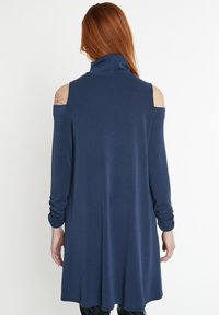Navyblaues, langärmliges Kleid mit hohem Kragen, Cold-Shoulder-Design und lockerer Passform mit gerafften Ärmeln. Glatte Textur.
