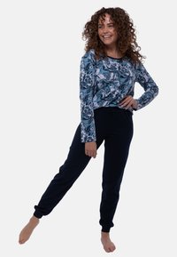 Top à manches longues à motif floral dans des tons de bleu, associé à un pantalon de jogging navy. Tissu doux, coupe décontractée, taille élastique.