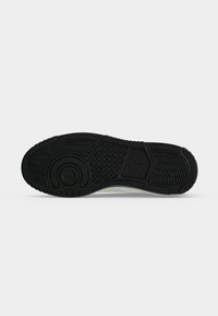 Μαύρη λαστιχένια σόλα αθλητικού παπουτσιού με υφασμένα σχέδια πρόσφυσης και μικρό λογότυπο Puma στο τμήμα της καμάρας.