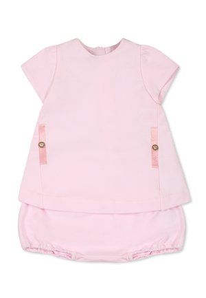 Roze katoenen outfit met korte mouwen, voorzien van satijnen accenten aan de zijkanten en gouden knoopdetails, gecombineerd met gerimpelde bloezers.