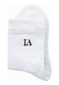 Calcetines deportivos blancos hechos de una tela suave, con textura acanalada y un logotipo negro de "LA" en el puño. Acabado liso con punta redondeada.