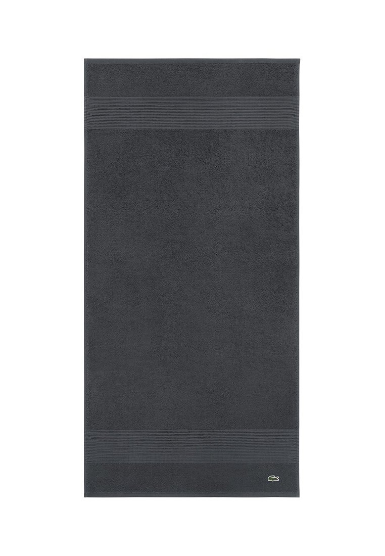 Toalla gris oscuro de algodón texturizado, con un color sólido y sutiles rayas, además de un pequeño logo en la esquina inferior.