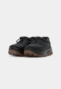 Sorte quilted slip-on sko med rund tå, gummisåle og teksturert såle. Har en justerbar snor på oversiden.