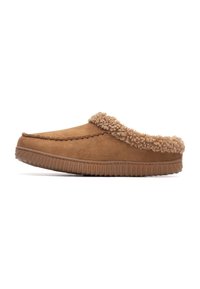 Zapatillas de ante marrón con un forro de piel de tono claro texturizado, punta redondeada y suela de goma estriada para mayor agarre. Diseño sin talón y de fácil poner.