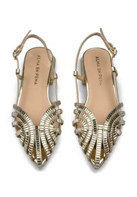 Bailarinas doradas con talón descubierto y puntera afilada, con intrincados detalles metálicos. Correas texturizadas y una plantilla suave en color beige. Correa en el tobillo ajustable.