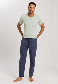 Lichtgroen v-hals t-shirt gecombineerd met marineblauwe gestreepte pyjamabroek, met een koord in de taille en rechte pijpen. Eenvoudige, casual uitstraling.