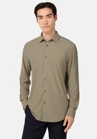 Licht khaki langarmshirt met een klassieke kraag, knoopsluiting en een soepele stof. Beschikt over een ronde zoom en knoopmanchetten.