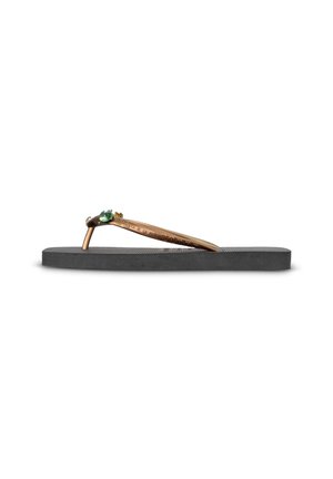 Tongs en caoutchouc noir avec bride de couleur bronze ornée de petites pierres décoratives sur fond blanc.