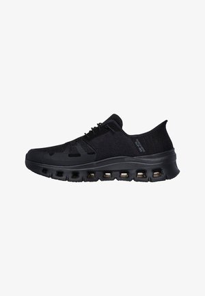 Zapatilla deportiva negra con parte superior tejida transpirable, cierre de cordones y suela gruesa acolchada con múltiples aberturas de ventilación.