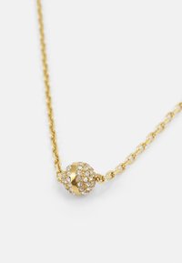 Gold necklace featuring a spherical pendant adorned with sparkling rhinestones and a horizontal gold stripe, attached to a twisted chain.