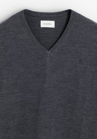Tmavě šedý svetr s v- výstřihem vyrobený z měkké tkaniny, se subtilním logem na hrudi a ribbed detaily na výstřihu. Velikost XL.