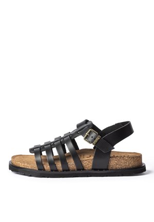 Sandalia de cuero negro con múltiples tiras, hebilla dorada ajustable, plantilla de corcho y suela de goma negra, mostrada en perfil lateral.