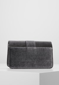 Borsa clutch in velluto grigio con una texture liscia, forma rettangolare e patta pieghevole. Presenta sottili dettagli di cuciture orizzontali.