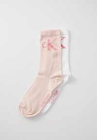 Kokvilnas maisījuma zeķes gaiši rozā un baltā krāsā. Ribota augšpuse, "Calvin Klein" logo rozā krāsā un bezšuvju pirkstu dizains komfortam.