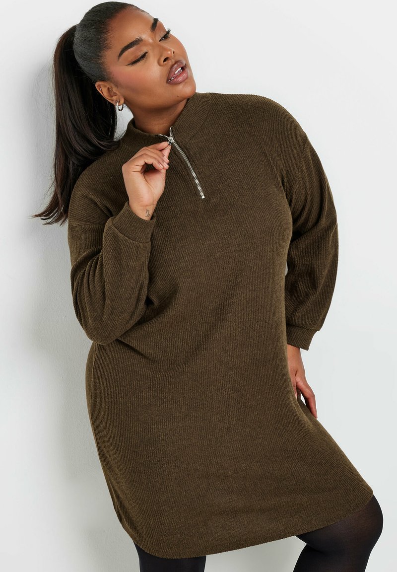 Abito pullover a coste marrone con colletto alto e dettaglio zip argentato. Presenta maniche lunghe e una vestibilità rilassata, che arriva a metà coscia.