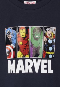 Marineblaue T-Shirt mit vier Marvel-Charakteren: Captain America, Iron Man, Hulk und Thor. Fetter, weißer "MARVEL"-Text darunter. Illustrationen im Comic-Stil.