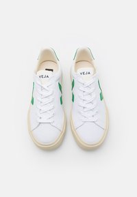 Sneakers in tela bianca con accenti in gomma verde, punta tonda, lacci piatti e suola in gomma beige. Marchio sulla linguetta.