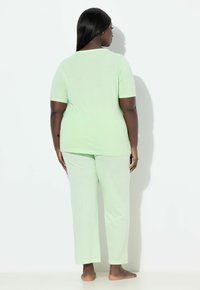 Hellgrünes Pyjama-Set mit kurzärmeligem Oberteil und geraden Hosenbeinen mit subtiler Textur, entworfen für Komfort und Entspannung.