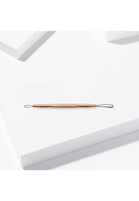 Dubbelzijdig verwijderingsinstrument voor mee-eters in roségoud met een geribbelde grip, met een kleine lus aan de ene kant en een grotere lus aan de andere kant.