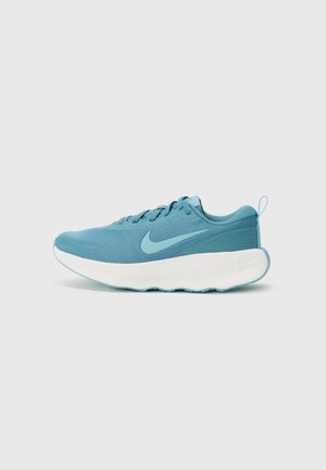 Jasnoniebieskie buty sportowe z siateczkową cholewką, wyściełanym kołnierzem i białą podeszwą. Posiadają wyraźne logo w kształcie łyżwy po boku oraz teksturowany akcent na pięcie.