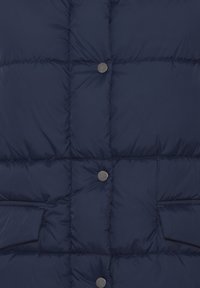 Vest de tip puffer de culoare bleumarin, cu un design matlasat, nasturi metalici și buzunare laterale, având o textură netedă și lucioasă.
