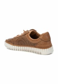 Zapatillas de cuero marrón con diseño perforado, suela de goma blanca y acentos cosidos. La vista lateral muestra una punta redondeada y un cierre con cordones.