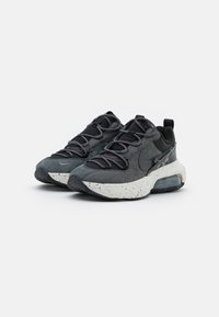 Svarta och grå atletiska sneakers med överdel i mocka och mesh, rundad tå, texturerade detaljer och prickig vit mellansula med luftdämpning.