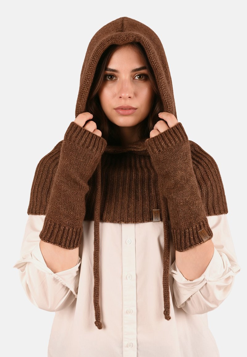 Poncho tricotat maro cu glugă și mănuși fără degete; prezintă o textură ribbed, șnur de ajustare și etichetă cu brand pe mânecă.