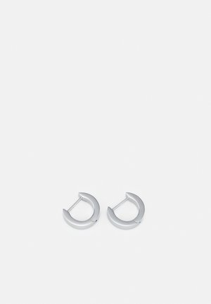 Silver hoop earrings with a smooth, metallic finish and a rounded crescent shape, featuring a slim post closure for wear.