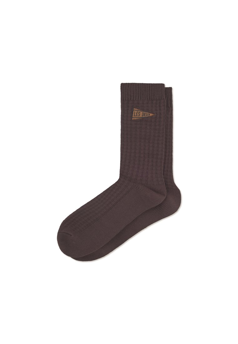 Calcetines marrones con canalé que presentan una pequeña etiqueta marrón con el texto "LES DEUX". Fabricados en un material suave y texturizado. Diseño de altura de tobillo.