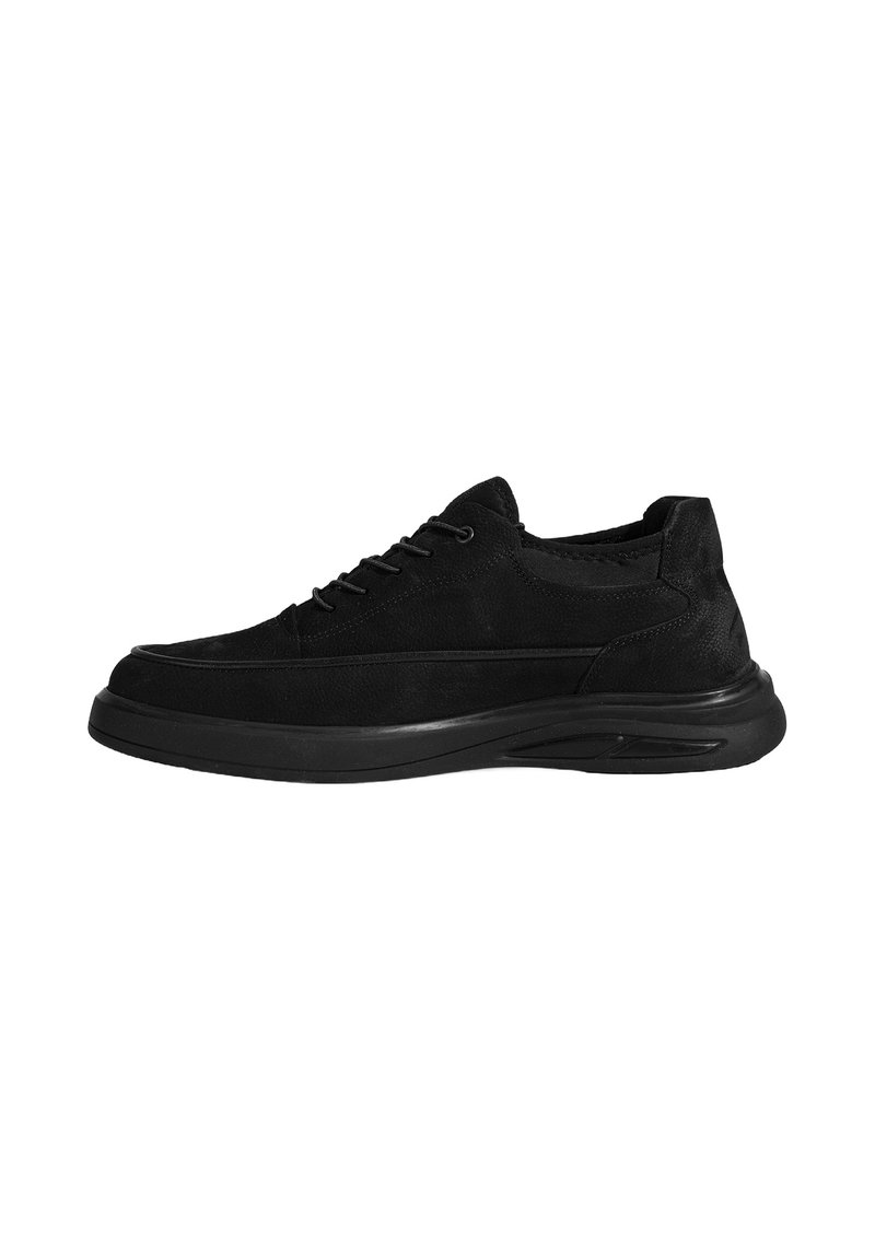 Black suede sneaker with a rounded toe, lacing system, and a thick rubber sole. Features a textured upper and contrasting stitching details.