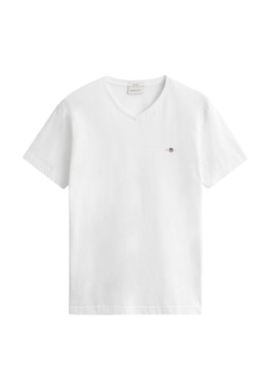 Weißes kurzärmeliges V-Ausschnitt-T-Shirt mit kleinem besticktem Schild-Logo auf der linken Brust, dargestellt auf weißem Hintergrund.