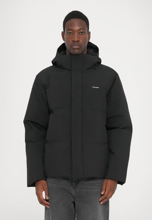 Schwarze Pufferjacke mit hohem Kragen und verstellbarem Kapuzen, ausgestattet mit einer glatten Textur und minimaler Markenkennzeichnung auf der Brust.