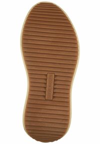 Brun gummisål med vandrette riller, der har et indgraveret "STEVE MADDEN" logo på en flad sektion nær hælen.