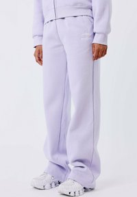 Lila sweatpants van zachte fleece, met een relaxte pasvorm, zijzakken en een witte geborduurde logo op de linkerheup.