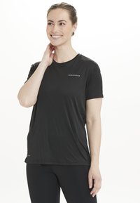 Schwarzes Sportshirt mit kurzen Ärmeln aus leichtem, feuchtigkeitsableitendem Material. Verfügt über einen Rundhalsausschnitt und ein dezentes "ENDURANCE"-Logo auf der Vorderseite.