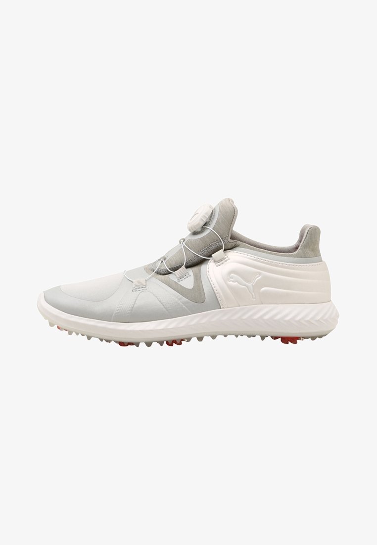 Chaussure de sport moderne blanche et grise avec une semelle texturée, sans lacets visibles et un système de serrage circulaire sur la partie supérieure.
