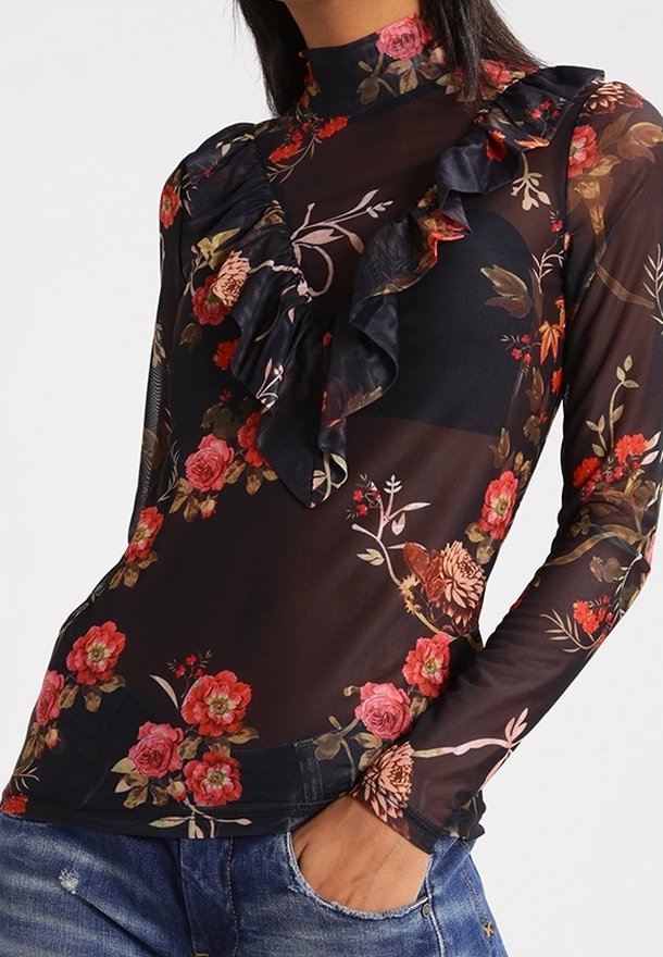 Top nero trasparente con motivo floreale in rosso, rosa e verde. Presenta dettagli arricciati lungo il colletto e maniche lunghe.