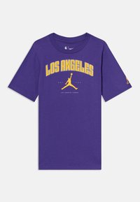 Lilla bomull T-skjorte med «LOS ANGELES» i gult tekst over et Jumpman-logo. Rund hals med korte ermer og vanlig passform.
