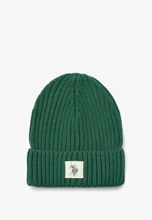 Dark green ribbed knit beanie with a turned-up cuff and a square label featuring a gray illustration of a figure on horseback.