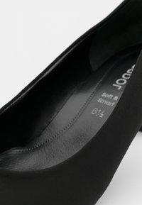 Zwarte balletflat met een gladde, matte afwerking en een ronde neus. Het interieur is voorzien van zachte vulling; maatlabel is zichtbaar als 6½.