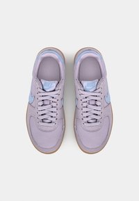 Baskets avec une tige en tissu lilas, des accents bleu clair et des semelles en caoutchouc marron. Comprend des lacets ronds et un design profil bas.