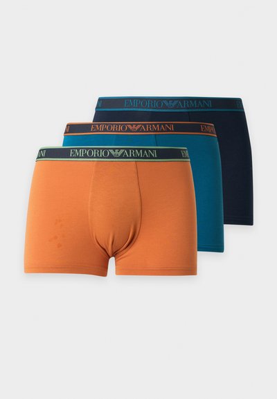 Trois paires de boxers pour hommes Emporio Armani en orange, bleu sarcelle et marine, avec des ceintures de marque assorties.