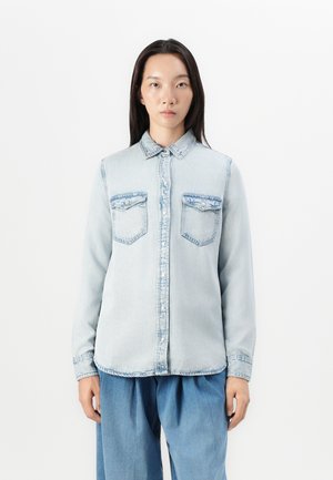 Lichtblauw denim overhemd met een knoopsluiting aan de voorkant, twee borstzakken en een standaard kraag. Heeft zichtbare stiksels en een zachte textuur.